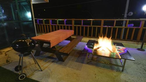 a fire pit with a bench and a grill at Gapyeong Sangol Spa Pension in Gapyeong