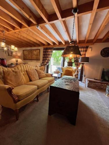 a living room with a couch and a table at vakantiewoning met jacuzzi Forêt d'Animaux in Frahan