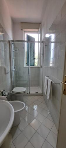 a bathroom with a shower and a toilet and a sink at Hotel Villa Tiziana in Marina di Pietrasanta