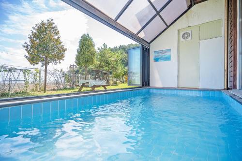 a swimming pool in a house with a large window at Daebudo sunshine kids poolvilla in Ansan