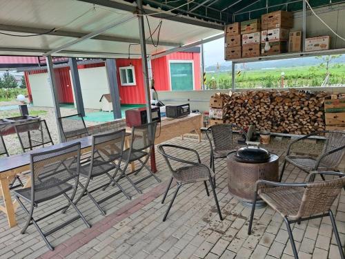 a patio with chairs and a table and a grill at Goseong Sustay Pension in Goseong