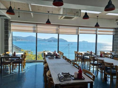 a restaurant with tables and chairs and a view of the ocean at Geoje Marepos Pension in Geoje 