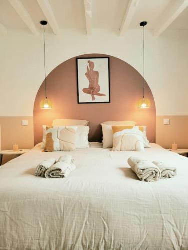 un grand lit blanc avec deux oreillers dessus dans l'établissement La Vie en Rose, à Barentin