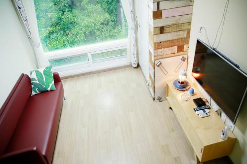 a living room with a red couch and a window at Paju Maribyeol Pension in Saech'aei