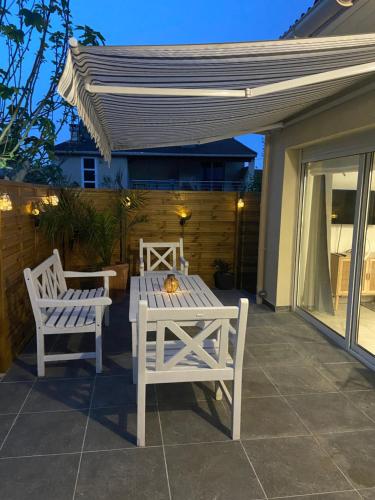 - une table blanche et 2 chaises sur la terrasse dans l'établissement Maison Parking-10 min Aéroport, à Orly