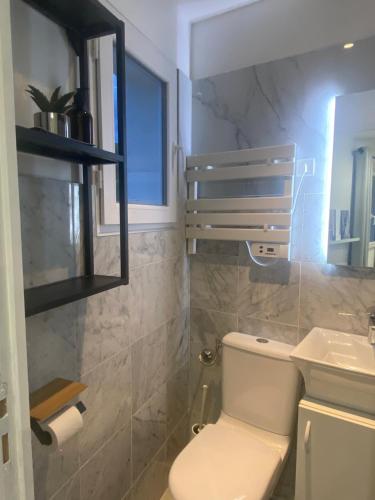 une salle de bain avec toilettes et lavabo dans l'établissement Maison Parking-10 min Aéroport, à Orly