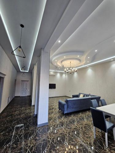 a living room with a blue couch and a table at Mardakan Villa in Əzizbǝyov