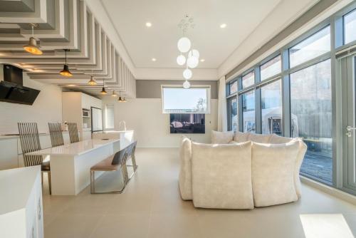 a living room with chairs and a table and windows at Gangneung Uahaeng Stay Private House in Gangneung