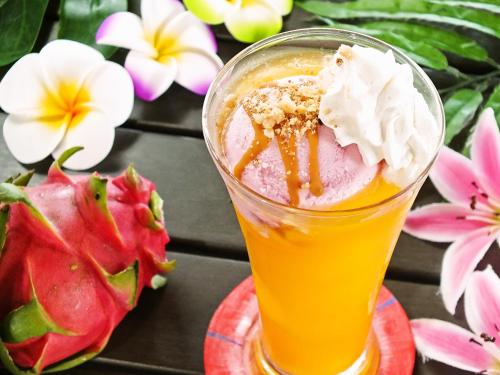 a drink with ice cream and fruit on a table at Ma-Blue Garden House in Motobu