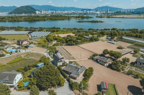 an aerial view of a house next to a river at Chuncheon Viandante Dokchaehanok in Chunggan-mal