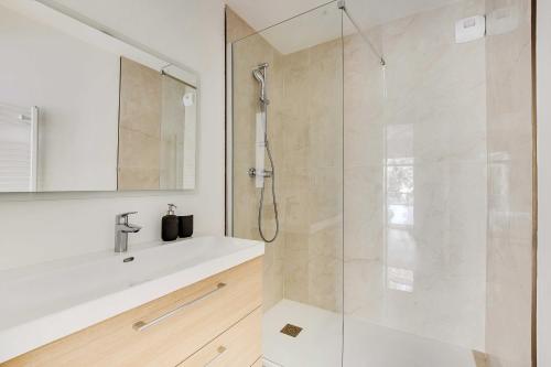 une salle de bain blanche avec une douche et un lavabo dans l'établissement Chic Duplex with Rooftop -3BD-6P- Nogent-sur-Marne, à Nogent-sur-Marne