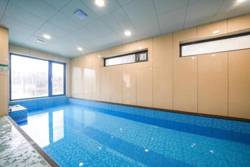 a large swimming pool in a room with blue tiles at GaPY Mom Stay Private Pool Villa in Gapyeong