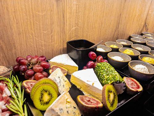 a table with different types of cheese and fruit at Sweet Cherry - Boutique & Guesthouse Tyrol in Innsbruck