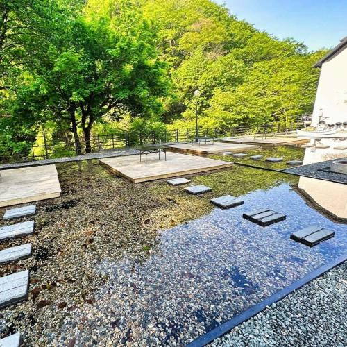 a garden with a pond with rocks and trees at Sokcho Floating Whale Seorak Dojeok Waterfall Stay in Inje