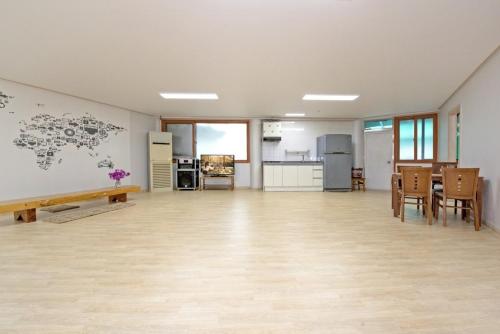 an empty room with a table and chairs and a kitchen at Gapyeong Gangbyeonmaru Pension in Gapyeong
