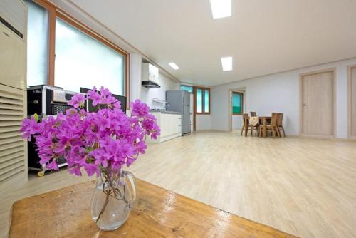 a vase filled with purple flowers sitting on a table at Gapyeong Gangbyeonmaru Pension in Gapyeong
