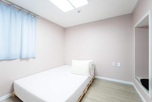 a white room with a bed and a window at Gangneung Dawon Forest Private Pension in Gangneung