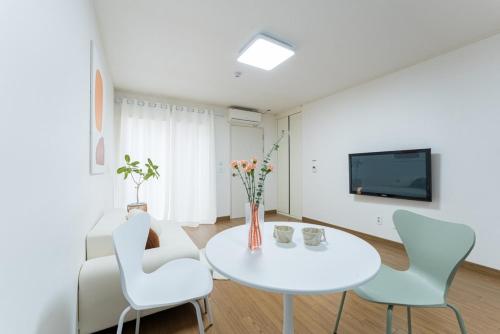 a white dining room with a white table and chairs at Paju Stay 29 in Paju