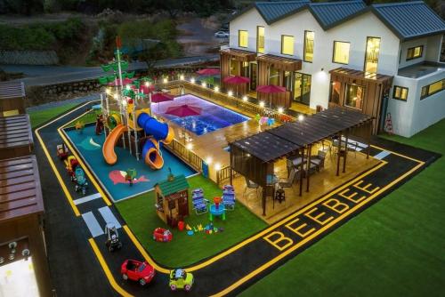 a model of a house with a playground in the backyard at Gapyeong BB Kids Pool Villa in Sŏri-gol