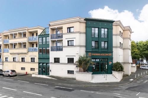 un immeuble d'appartements vert et blanc dans l'établissement Résidence Pierre & Vacances Centre, à La Rochelle
