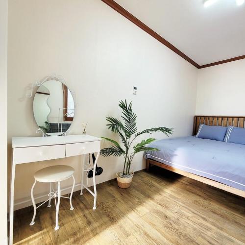 a bedroom with a bed and a dressing table and a mirror at Pyeongchang Heungjeong Valley 409 Pension in Pyeongchang 