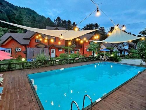 a large swimming pool in front of a house at Eoullim Pension - Moonlight Yard in Pyeongchang 