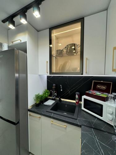 a kitchen with a sink and a microwave at Iasi Ultra Central Apartment Self Check-In in Iaşi
