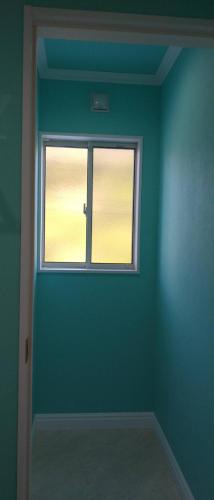 an empty room with a window and a green wall at 栗山さん家のアロハミエント in Shirahama