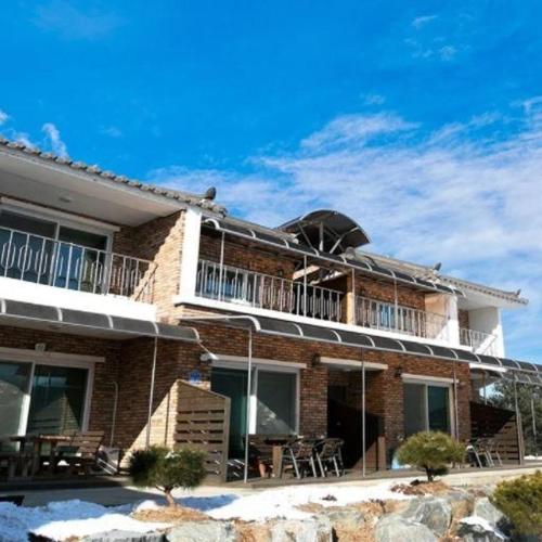 a building with a balcony with tables and chairs at Yanggu Dandelion Pension in Yanggu