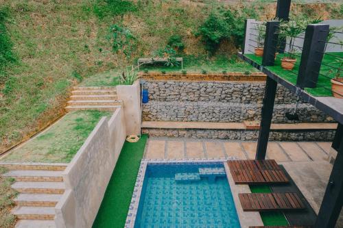 a small swimming pool in a garden with stairs at D Pine Villa in Bukit Tinggi