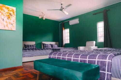 a green room with two beds and a green wall at D Pine Villa in Bukit Tinggi