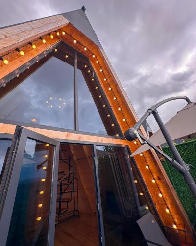 a roof deck with a glass door and lights at Turo House in Batumi