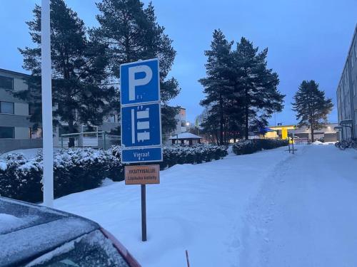 a blue parking sign in the snow next to a car at Satakieli - 2 bedroom apartment incl free parking and wifi max 5 person in Harjavalta
