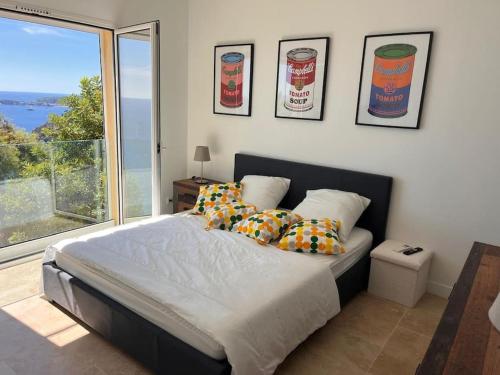 une chambre avec un lit et une grande fenêtre dans l'établissement De la mer aux citronniers, à Èze