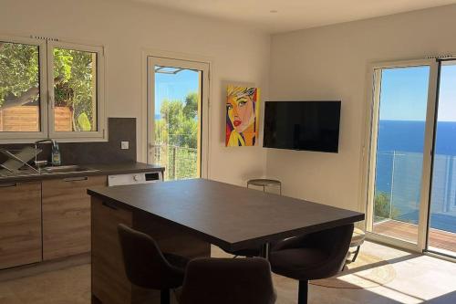 une cuisine avec une table et des chaises ainsi qu'une télévision dans l'établissement De la mer aux citronniers, à Èze