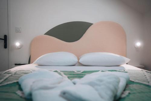 - un lit avec une tête de lit et des oreillers dans l'établissement L'Évasion - Authentique & Chill - Premium, à Châteauroux