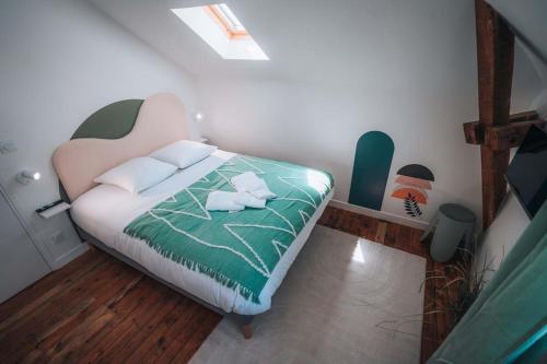 - une chambre dotée d'un lit avec une couverture verte et blanche dans l'établissement L'Évasion - Authentique & Chill - Premium, à Châteauroux