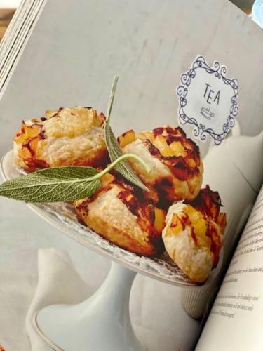 three pastries on a glass plate on a book at Gästehaus Weiherhof in Alpbach