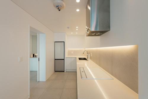 a white kitchen with a counter top in a room at Pohang Case Poolvilla in Hajŏng-ni