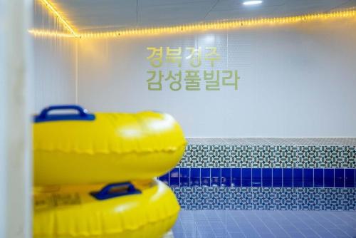 慶州市にあるGyeongju Danchae Gamsung Pool Villaの壁のある部屋に黄色い物が山積みになっている