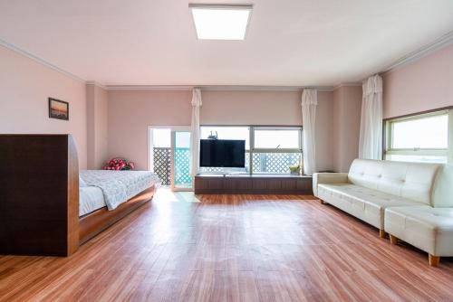 a large living room with a couch and a tv at Yeongheungdo Haesong Pension in Incheon