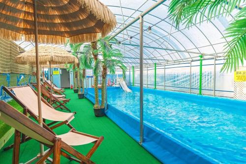 a pool with chairs and umbrellas in a resort at Taean Anmyeondo Badabi Pension in Kwik-kol