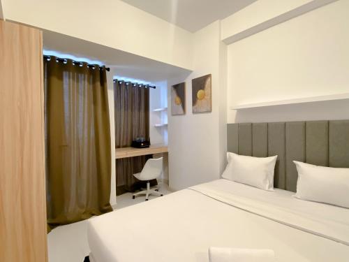 a bedroom with a bed and a desk at Restful and Good Deal Studio at Tokyo Riverside PIK 2 Apartment By Travelio in Rawalembang