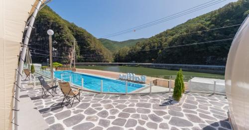 a view of a swimming pool with mountains in the background at Andong Luxury Glamping Lapine in Andong