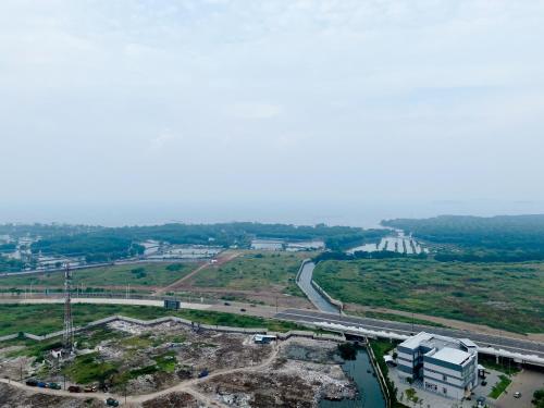 an aerial view of a city and a highway at Restful and Good Deal Studio at Tokyo Riverside PIK 2 Apartment By Travelio in Rawalembang