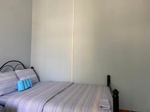 a bedroom with a bed with two blue pillows on it at COMFORT HAVEN Studio in Ilemera