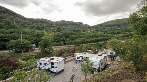 a group of rvs parked in a parking lot at Cheonan Youseongnongwon Caravan in Cheonan