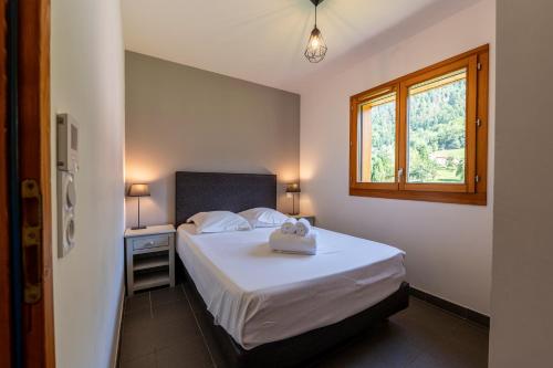 Un dormitorio pequeño con una cama y una ventana. en Chalet Arclosan - Val de Tamié, en Faverges