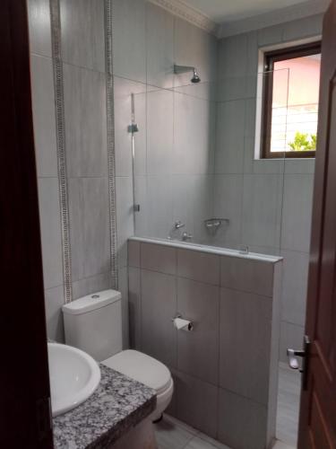 a bathroom with a toilet and a sink at Twiga Whitehouse Villa in Nakuru
