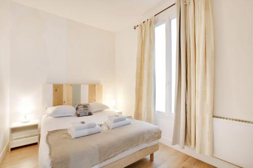 - une chambre blanche avec un lit et des serviettes blanches dans l'établissement Newly restored appartment - Montmartre, à Paris